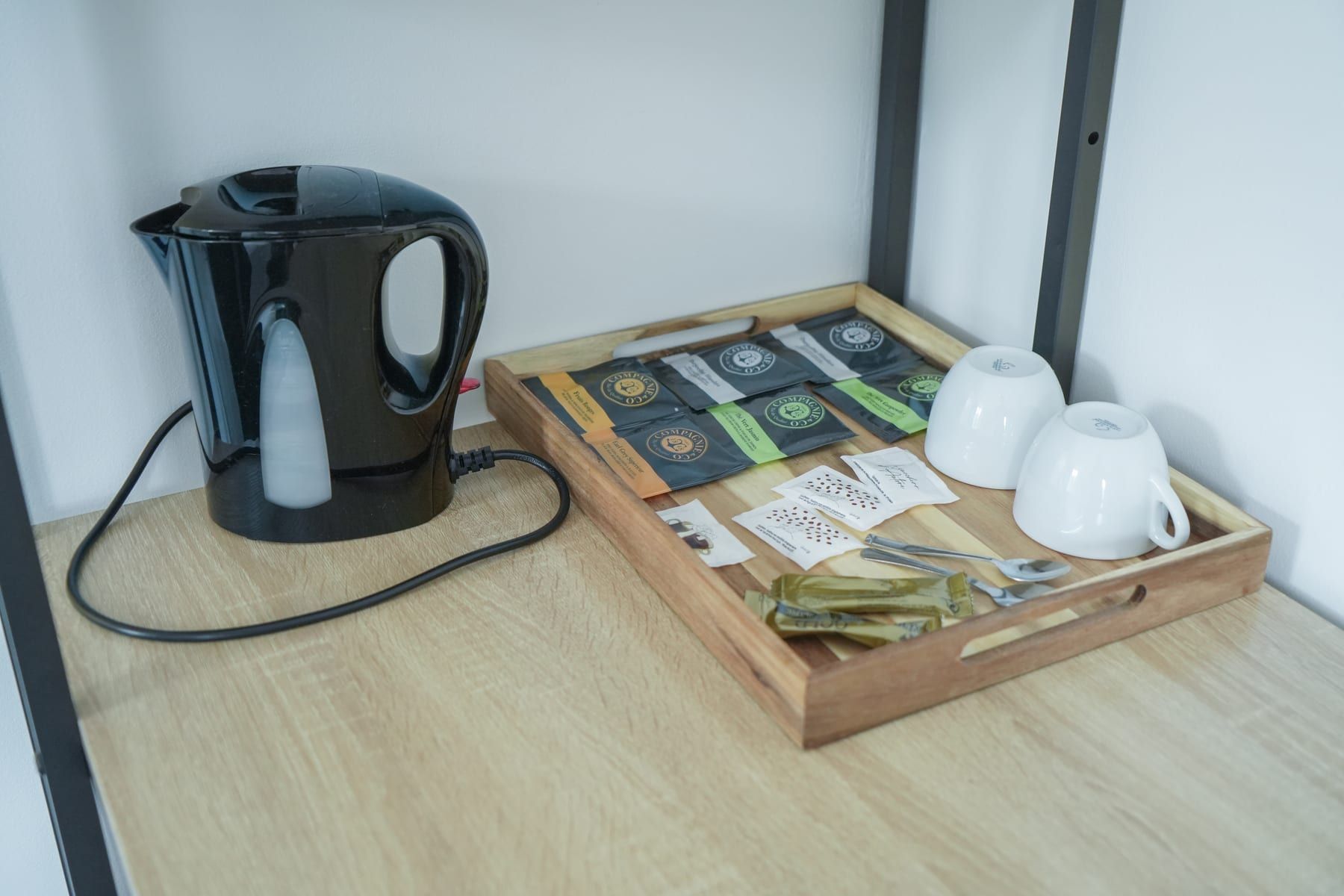 Plateau de courtoisie en chambre : bouilloire, tasses et sélection de thés et cafés