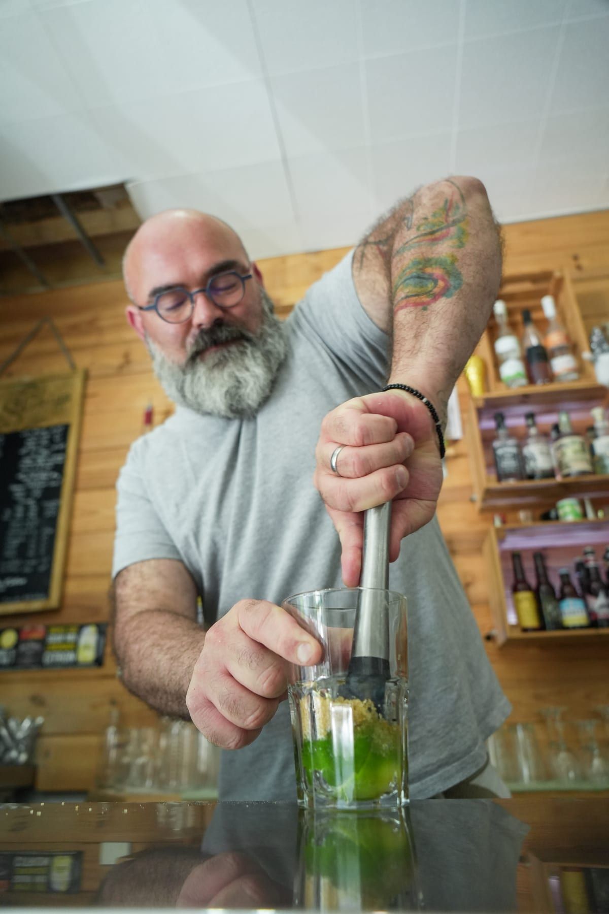 Préparation d'une caïpirinha : citron vert pilé au bar