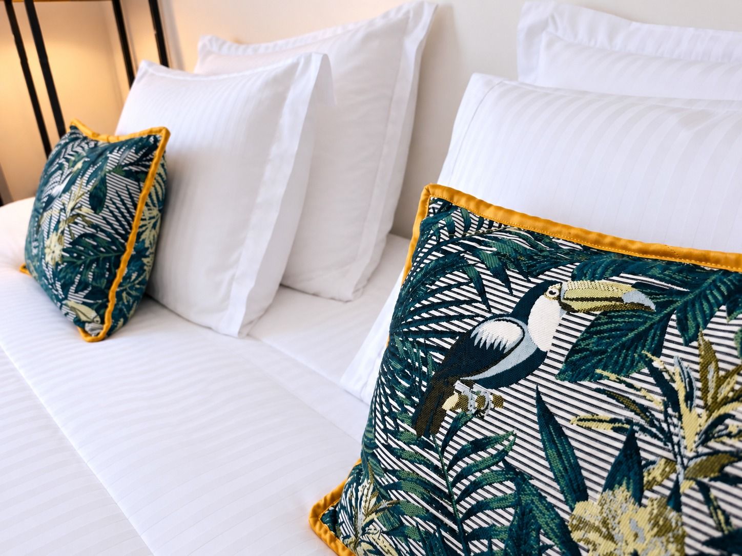 Coussins à motif toucan sur le lit de la Chambre Double Deluxe