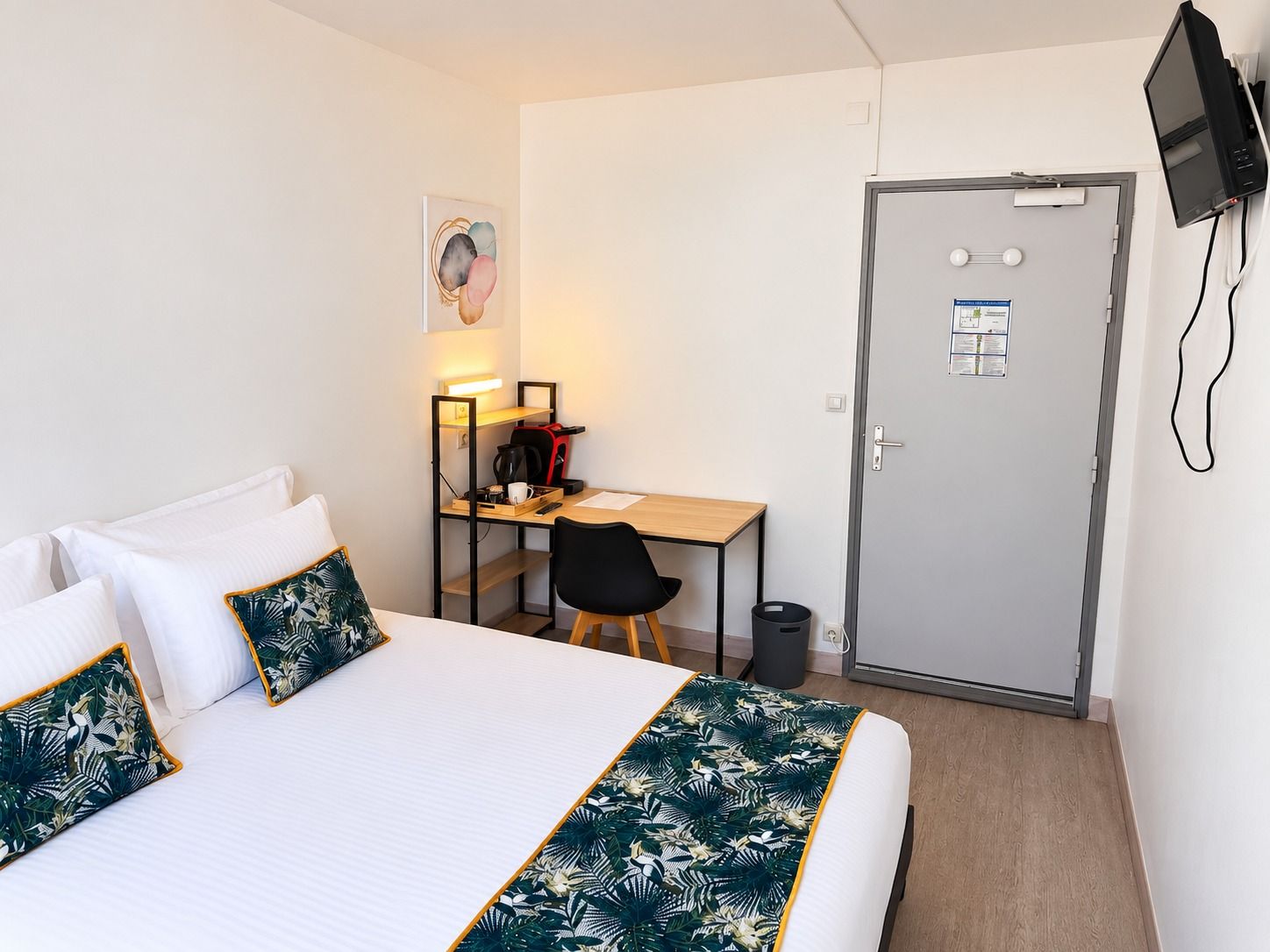 Chambre Double Deluxe côté porte, avec le bureau et la télévision