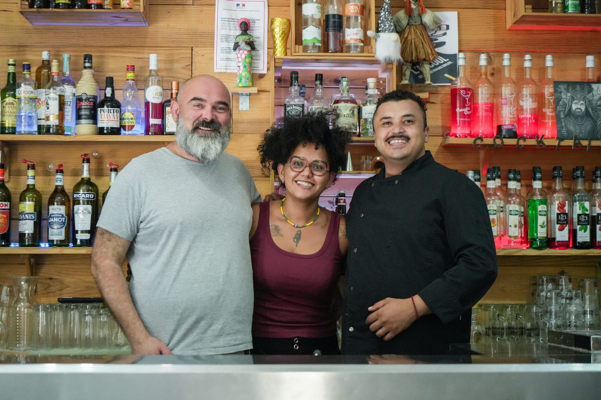 Sébastien, Amanda et Tiago, souriants derrière le bar d'Ice Rock Brasil