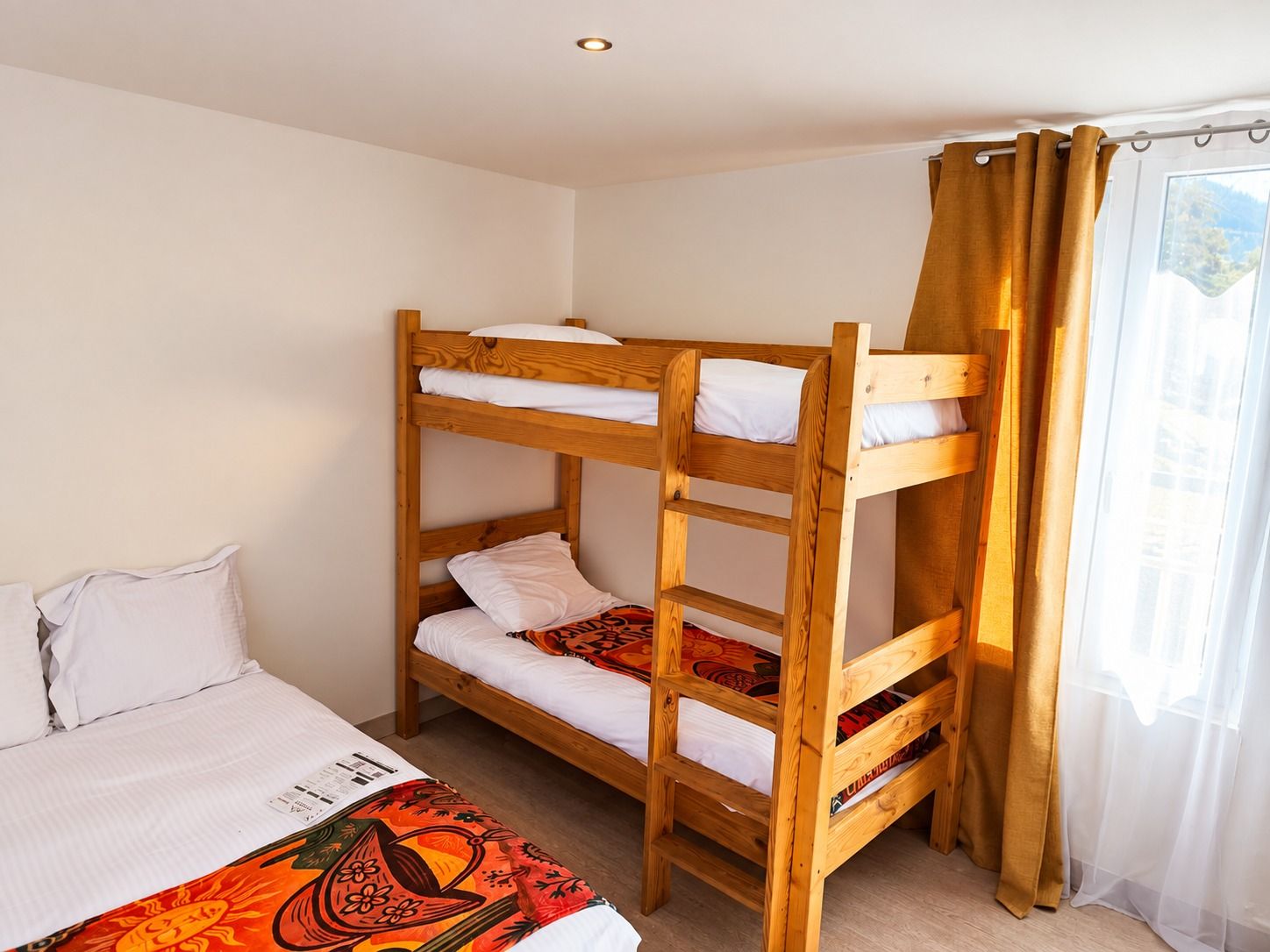 Lits superposés en bois de la Chambre Familiale, plaids aux couleurs du Brésil
